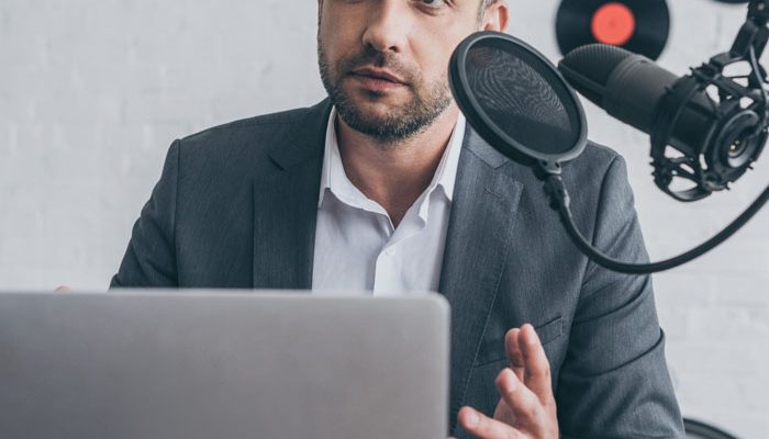 handsome-radio-host-gesturing-while-speaking-in-mi-XD6LB63.jpg